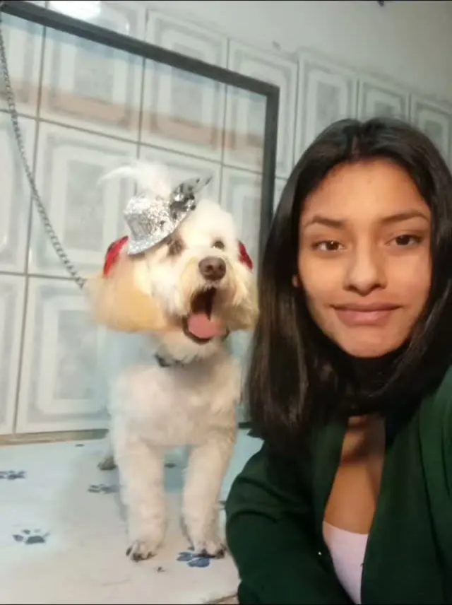 La peluquera de PG junto a un perrito maltés con gorrito